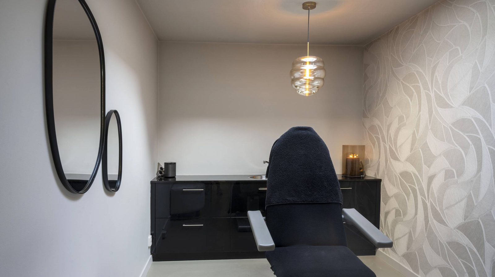 Behandelkamer met behandelstoel en ronde spiegels